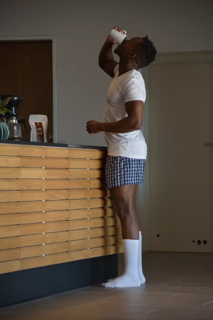 Mann in Unterwäsche trinkt Morgenkaffee.