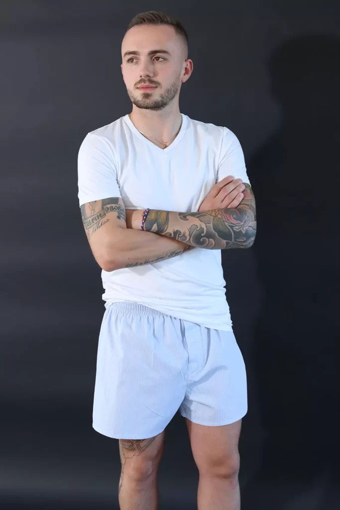 Mann trägt weißes T-Shirt und hell-blaue Boxershorts