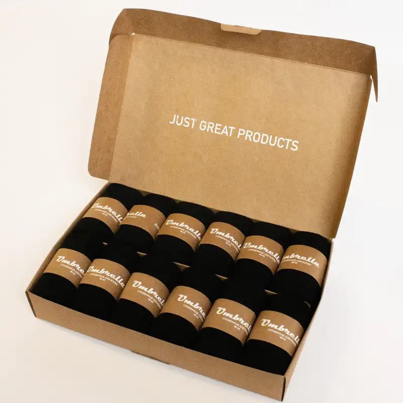 12er Pack schwarze Bambus Socken in geöffneter brauner Verpackung.